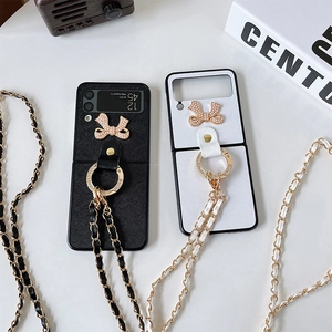 Detail of Galaxy Z Flip phone case with rhinestone bow, ring holder, and crossbody strap