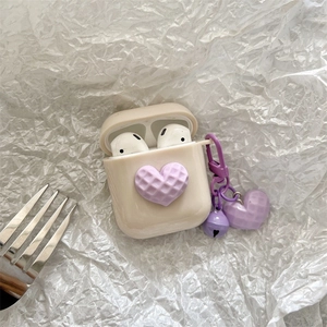 Dettaglio custodia AirPods crema con cuore waffle 3D viola e cinturino con ciondolo cuore