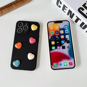 Custodia per iPhone opaca con cuori 3D colorati su un vassoio di legno di tendenza