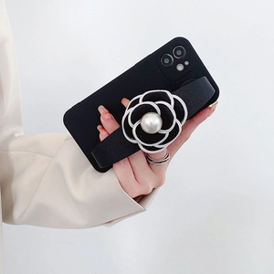 Detail of iPhone case featuring a black camellia flower with pearl and leather wrist strap
