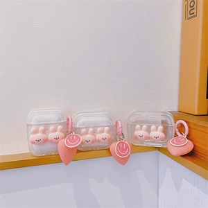 Detailed view of clear AirPods case featuring pink 3D bunny and heart charm pendant