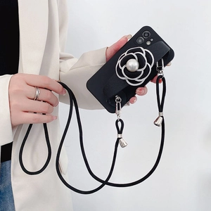 Detail of iPhone case featuring a white camellia flower with pearl and long crossbody strap