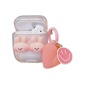 Clear AirPods case featuring pink bunnies, heart charm and smile tag on white background