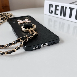 Detail of Galaxy Z Flip case with rhinestone bow, ring grip, and crossbody chain strap