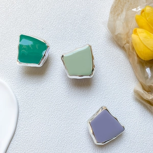 Close-up of geometric plated metal phone grips with green and purple enamel finish