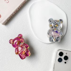 Detail of cute bear-shaped phone grip with glitter and gold foil in transparent resin