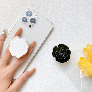 Detail of elegant black and white camellia flower phone sockets on a white smartphone