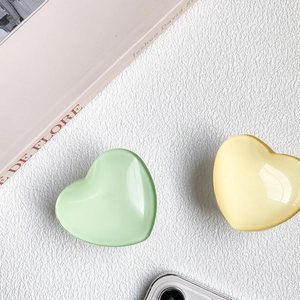 Gros plan de supports de téléphone rétractables en forme de cœur, vert et jaune