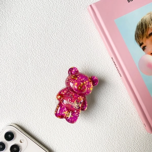 Detail of pink resin bear phone grip with gold star sequins and Sweet lettering