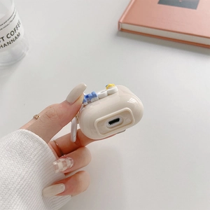 Detailed view of off-white AirPods case with colorful 3D letters and side hanging loop