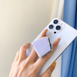 Detail of lavender geometric phone grip with silver metallic frame on a white smartphone