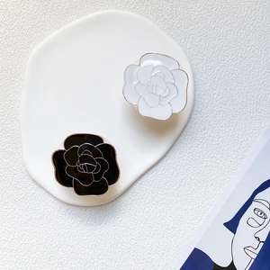 Elegant camellia phone sockets in black and white with gold-plated edges on ceramic tray