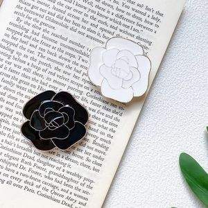 Detailed view of black and white camellia flower phone grips with gold electroplated edges