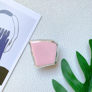 Macro detail of a pink geometric collapsible phone grip with stylish silver metallic edges