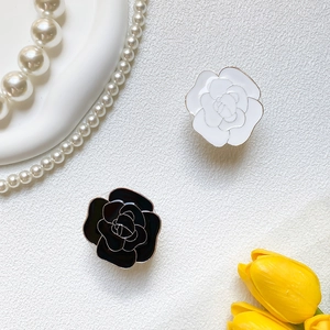 Detail of rose-shaped gold-plated phone sockets in black and white enamel finish