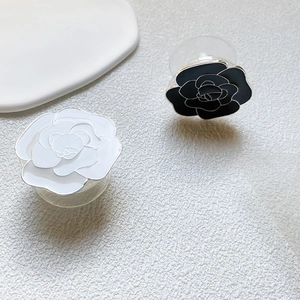Detailed macro view of camellia flower cell phone stands in black and white finish