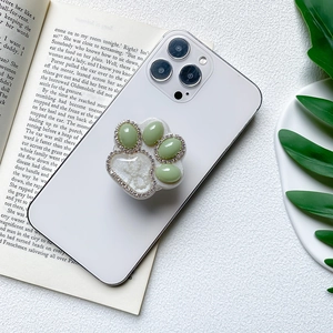Creative 3D cat paw phone grip with green gemstones and sparkling diamond rim