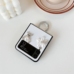 Close-up of white leather texture phone case with rhinestone bear and pearl flower detail