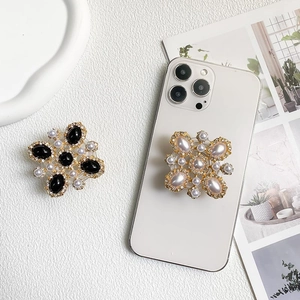 Luxurious rhinestone cell phone grip with onyx and pearl inlay on a gold alloy frame