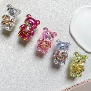 Macro detail of glitter resin bear charms with pearl flowers and sparkling sequins