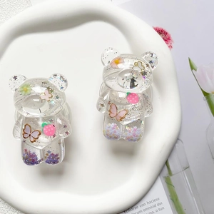 Close-up of bear-shaped phone grip with glitter, flowers, and butterfly resin detail