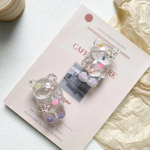 Transparent bear-shaped phone grip with pink flowers and glitter for mobile desk support