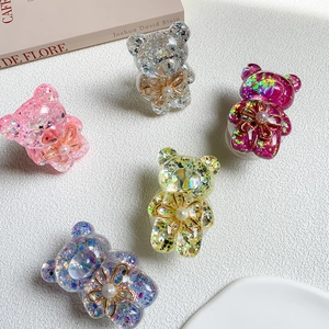 Close-up of bear-shaped glitter resin phone holders with pearls and golden floral details