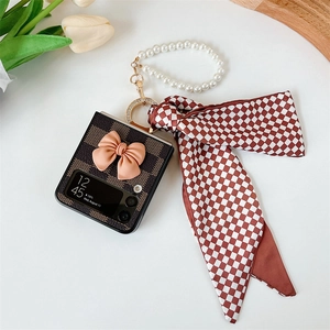 Detail of Galaxy Z Flip case with pink bow, pearl handle and checkerboard ribbon