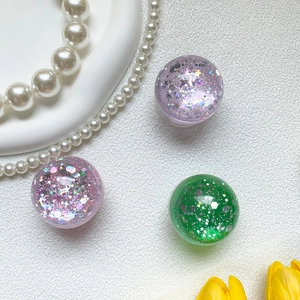 Macro detail of sparkly glitter crystal ball phone grips in pink and green colors