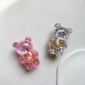 Close-up of pink and silver glitter bear phone grips with pearl flower detail