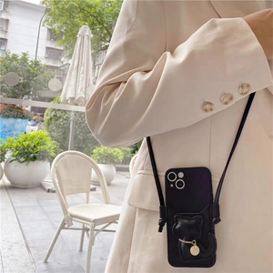 Close-up of a black leather cat-themed crossbody phone case bag with a gold pendant