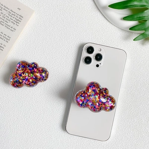 Cloud-shaped phone grip with colorful glitters and sequins on a white smartphone