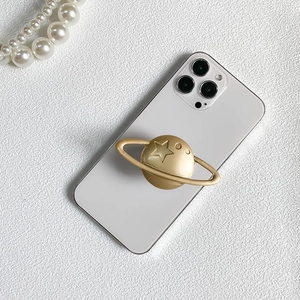 Gold planet phone socket grip with star engraving on white phone with pearls