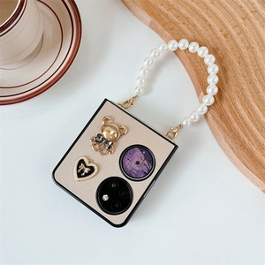 Detail of folding phone case with pearl wrist strap and sparkling metal bear charm