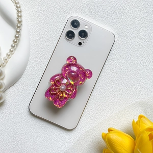Pink glitter bear phone socket holder with pearl flower on white smartphone back