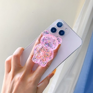 Pink glitter bear phone socket holder with floral resin detail shown on a purple smartphone