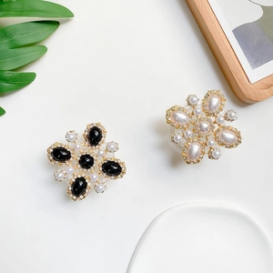 Detailed view of floral phone grips with pearls and rhinestones on a white background