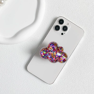 Macro view of a cloud-shaped phone socket filled with colorful glitter on a white phone