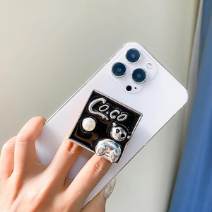 Detail der quadratischen Handyhalterung mit Bär, Perle und COCO-Schriftzug auf Handy