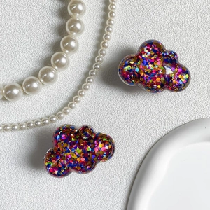 Macro detail of colorful sequin cloud-shaped phone grip with elegant pearl background