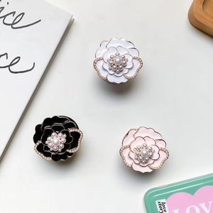 Detailed view of metal flower phone sockets with pearl accents in white black and pink