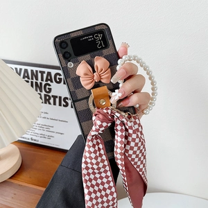 Checkerboard Galaxy Z Flip case with pink bow, pearl handle, and ribbon scarf charm