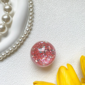 Detailed macro of pink glitter phone grip with silver stars and crescent sequins
