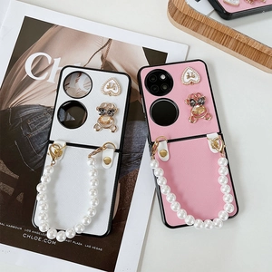 Detail of luxury pearl chain and diamond bear charm on foldable leather phone case