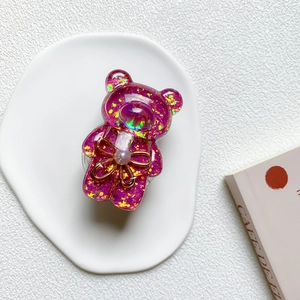 Macro detail of purple glitter bear phone grip with pearl and bowknot ornament