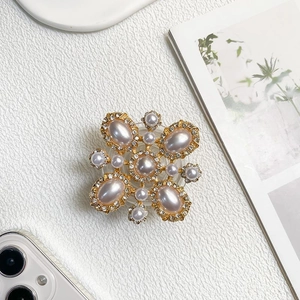 Detail of luxury rhinestone phone grip with vintage faux pearls in gold setting