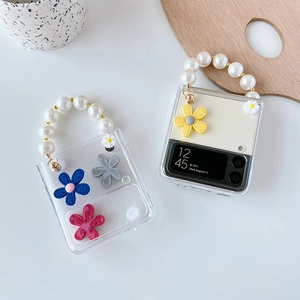 Detail of Galaxy Z Flip case with 3D daisy flowers and elegant pearl bead handle strap