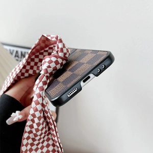 Detail of checkered leather phone case with red ribbon bow for folding smartphones