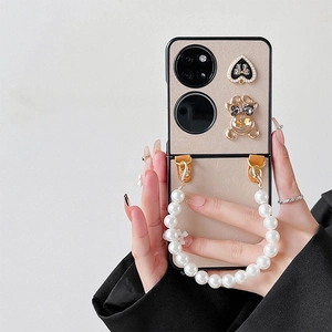 Detail of folding phone case with pearl heart, teddy bear charm and pearl handle strap