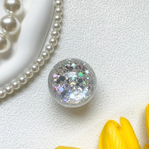 Close-up of glitter star and moon sequins inside the crystal phone grip ball